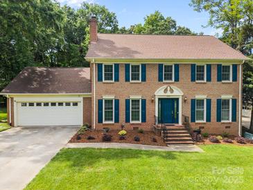 Charming brick two-story home with well-manicured lawn and attached two car garage at 9001 Peyton Randolph Dr, Charlotte, NC 28277