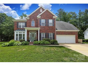 Beautiful two-story brick home with a well-manicured lawn and attached two car garage at 916 Cadogan Ct, Fort Mill, SC 29708