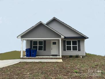 Charming single-story home with gray siding, a covered porch, and neatly landscaped front yard at 003 West Ave, Wadesboro, NC 28170