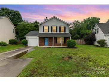 Charming two-story home featuring gray siding, brick accents, a well-manicured lawn, and a single-car garage at 2903 Rockingham Sw Ct, Concord, NC 28025
