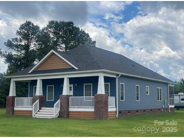 Charming blue home with a covered front porch, white columns, and manicured lawn at 6650 Highway 341 Hwy, Kershaw, SC 29067