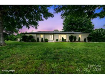 Charming one-story home with a well-manicured lawn and mature trees offering a serene outdoor setting at 806 N Central Ave, Locust, NC 28097