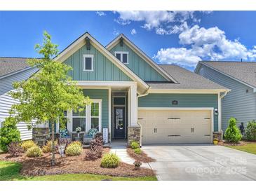 Charming, light green single-Gathering home with stone accents, a two-car garage and a welcoming front porch at 1133 Idyllic Ln, Waxhaw, NC 28173