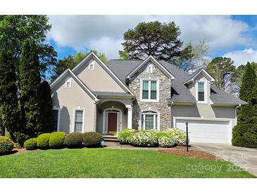Charming home featuring a stone facade, arched entryway, manicured landscaping, and a two-car garage at 1253 Iverleigh Trl, Charlotte, NC 28270