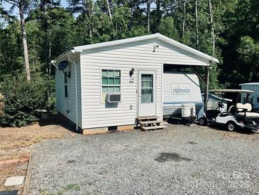 Quaint one-story home with white siding, complemented by an adjacent RV and golf cart at 146 Larboard Trl, Mount Gilead, NC 27306