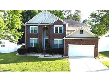 Charming two-story brick home with manicured lawn and attached two-car garage, located on a tree-lined street at 14615 Bridle Trace Ln, Pineville, NC 28134