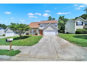 Charming two-story home features a well-manicured lawn, a long driveway, and a front-facing two-car garage at 2706 Stagbuck Dr, Gastonia, NC 28052