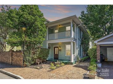 Charming two-story home with inviting front porch, lovely brickwork, and mature trees at 402 W 8Th St, Charlotte, NC 28202