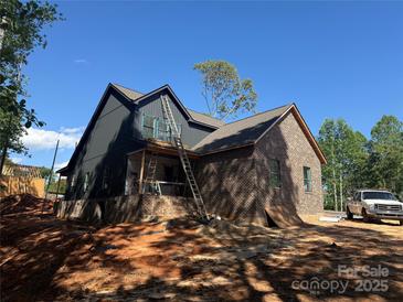 Two-story home under construction featuring a brick and gray corrugated metal exterior and ladder at 124 Third Se St, Hildebran, NC 28602