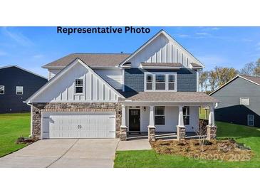 Charming two-story home featuring stone accents, a welcoming porch, and a two-car garage at 125 Asmodean Ln, Troutman, NC 28166