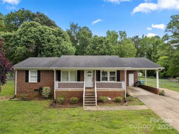 Charming brick home with a well-manicured lawn, covered front porch, and ample natural light at 128 Wandering Ln, Bessemer City, NC 28016