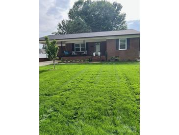 Charming brick ranch home with a well-maintained lawn, inviting front porch, and beautiful landscaping at 202 Kenwood Ave, Cherryville, NC 28021