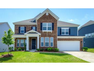 Beautiful two-story brick home featuring classic architecture, a manicured lawn, and attached garage at 256 W Waterlynn Rd, Mooresville, NC 28117