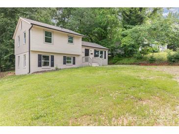 Charming two-story home with black shutters and ample front yard space nestled among mature trees at 3121 Revolution Park Dr, Charlotte, NC 28217