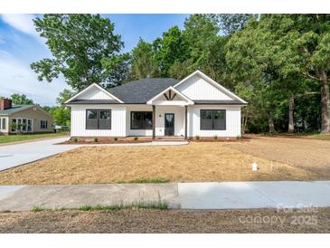 Charming new construction features a modern farmhouse exterior with manicured lawn at 315 W Hoke W St, Landis, NC 28088