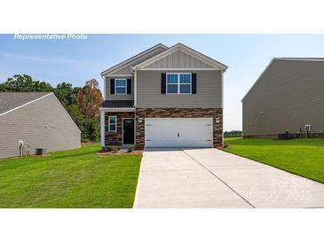 Charming two-story home featuring stone accents, gray siding, a two-car garage, and a well-manicured lawn at 3735 13Th Ne St, Hickory, NC 28601