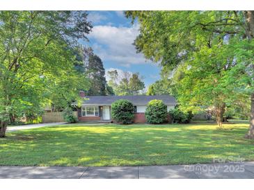 Charming single-story home with mature trees and a well-manicured lawn at 3951 Whitehall Dr, Charlotte, NC 28208