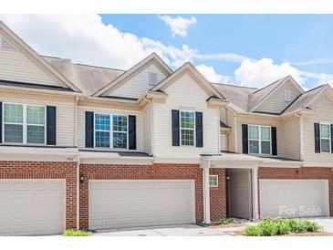 Inviting townhome featuring brick accents, an attached garage, and a covered front entry at 5951 Carrollton Ln, Charlotte, NC 28210