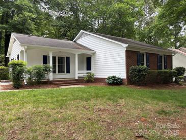 Charming home featuring a well-maintained lawn, a partial brick facade, and eye-catching blue shutters at 7212 Bradley Ct, Charlotte, NC 28227
