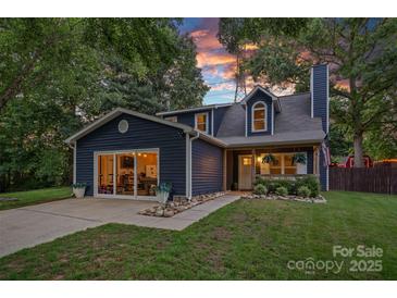 Charming home boasts curb appeal with a well-manicured lawn and inviting front porch at 8007 Maxwelton Dr, Huntersville, NC 28078