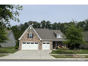 Charming, two-story home featuring a stone facade, manicured lawn, and a two-car garage at 1905 Tranquility Blvd, Lancaster, SC 29720