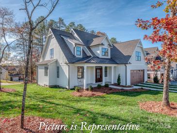 Charming two-story white home with a covered porch, manicured lawn, and beautiful landscaping at 3439 Stags Leap Way, York, SC 29745