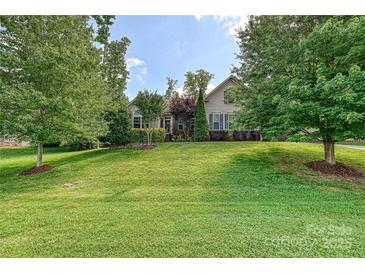 Charming single-story home with lush landscaping and a well-manicured lawn at 4018 Harmattan Dr, Denver, NC 28037