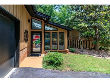 Inviting entrance with large windows, black trim, and colorful welcome decor, showcasing a blend of modern and classic design at 6119 Bittersweet Ln, Charlotte, NC 28270