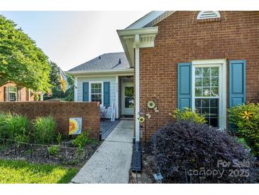 Charming home featuring a brick exterior, inviting walkway, and well-manicured landscaping at 9239 N Vicksburg Park Ct, Charlotte, NC 28210