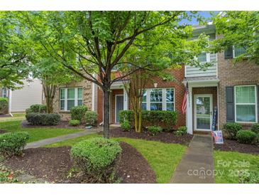 Inviting brick townhome with a landscaped front yard and walkway leading to the entrance at 18460 W Catawba Ave, Cornelius, NC 28031