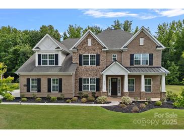 Stunning brick home featuring manicured lawn, elegant black shutters, and impeccable landscaping at 2185 Loire Valley Dr, Fort Mill, SC 29707