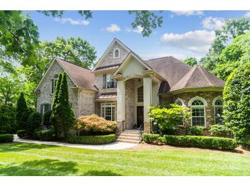 Stunning two-story brick home with a manicured lawn and lush landscaping creates great curb appeal at 6795 Montgomery Rd, Lake Wylie, SC 29710