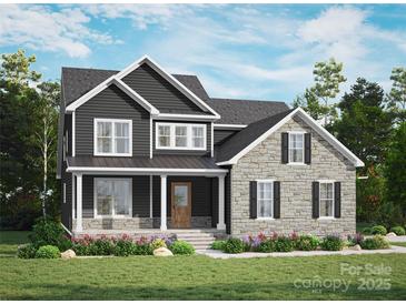 Beautiful two-story home with a stone and dark siding exterior, and a well-maintained lawn and colorful flowers at 7513 Lancaster Hwy # 6, Waxhaw, NC 28173