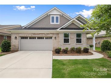 Charming single-story home featuring a brick facade, attached garage, and well-maintained landscaping at 9109 Liberty Hill Dr, Mint Hill, NC 28227