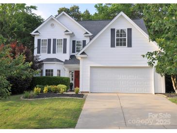Charming two-story home with a well-manicured lawn, a two-car garage and a striking red front door at 1051 Streamlet Way, Monroe, NC 28110