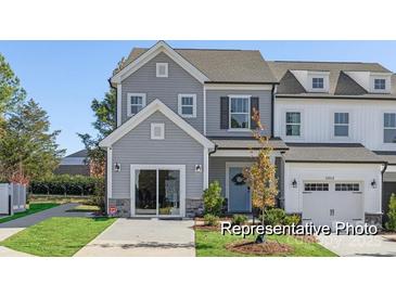 Charming new construction home with a two car garage and manicured lawn on a sunny day at 11619 Sapsucker Ln # 65, Charlotte, NC 28215
