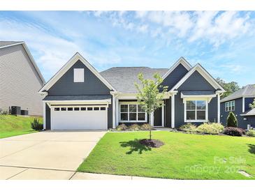 Charming home showcasing well-maintained lawn, blue siding, and inviting two-car garage at 163 Crenshaw Nw Pl, Concord, NC 28027