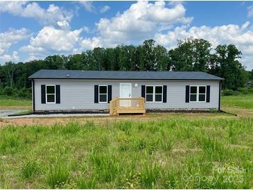 Charming single-story home with gray siding, black shutters, and a welcoming front porch in a serene setting at 188 Trivette Rd, Harmony, NC 28634