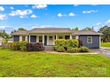 Charming single story home with well-maintained landscaping, blue siding, and white trim at 211 Ridgecrest St, Kannapolis, NC 28081