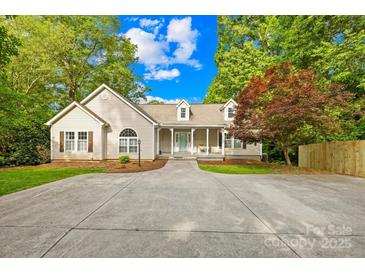 Charming home with a covered porch, manicured lawn, circular driveway and mature trees at 4120 Lake Shore S Rd, Denver, NC 28037