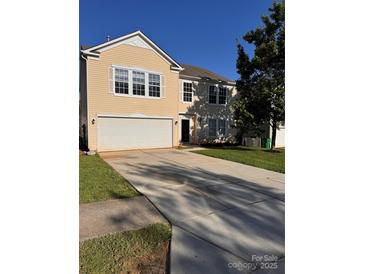 Charming two-story home with a two-car garage and a well-maintained lawn on a sunny day at 4521 Palustris Ct, Charlotte, NC 28269
