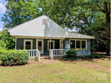 Charming single-story home featuring a covered front porch, light blue siding, and surrounded by mature trees at 647 Mckay Hill Rd, Mount Gilead, NC 27306