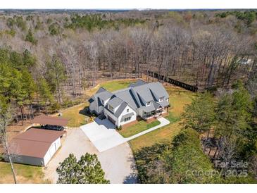 Expansive aerial view of a modern farmhouse-style home with a large yard, surrounded by dense trees at 722 Clegg Farm Dr, York, SC 29745