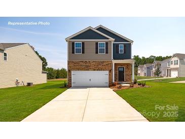 Two-story home boasts a manicured lawn, brick accents, and a two-car garage, embodying suburban charm at 1044 Horizon Ln, Chester, SC 29706