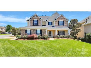 Charming two-story home featuring a beautifully manicured lawn and stone-accented facade at 1618 Bay Meadows Nw Ave, Concord, NC 28027