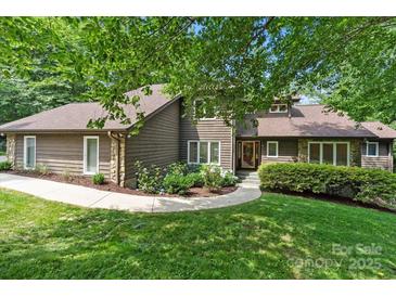 Charming two-story home features a manicured lawn, stone accents, and lush landscaping at 2045 10Th Street Nw Ln, Hickory, NC 28601