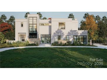 Modern home with a manicured lawn, large windows, stone accents, and a unique architectural design at 2861 Sharon Rd # 1, Charlotte, NC 28211