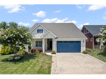 Charming single-story home featuring a blue garage door, well-maintained lawn, and beautiful landscaping at 467 Granite Lake Ct, Denver, NC 28037