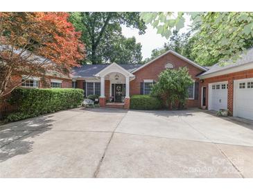 Charming brick home featuring a well-manicured yard and a welcoming front porch at 625 Saint Andrews Rd, Statesville, NC 28625