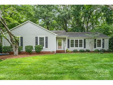 Charming single-story home with a lush green lawn and mature trees at 6749 Windyrush Rd, Charlotte, NC 28226